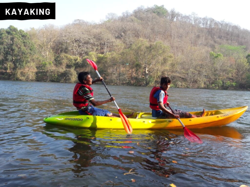 Kayakers paddling through the tranquil waters of Supa Reservoir in Dandeli